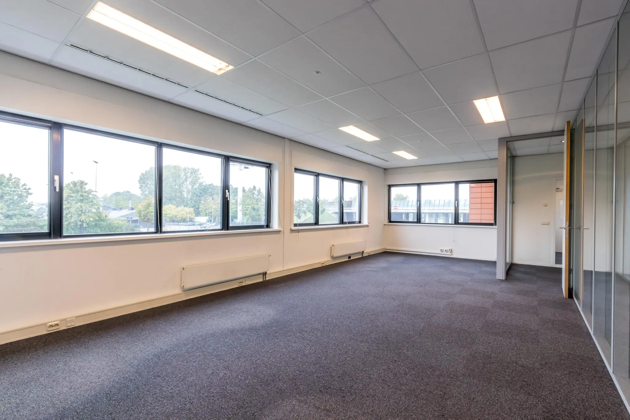 Licht en leeg kantoor met grote ramen aan de Lage Biezenweg.